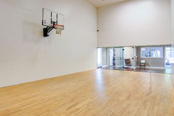 a large room with a basketball hoop and hardwood floors